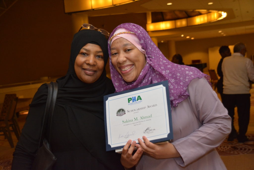 2 Women Holding Award